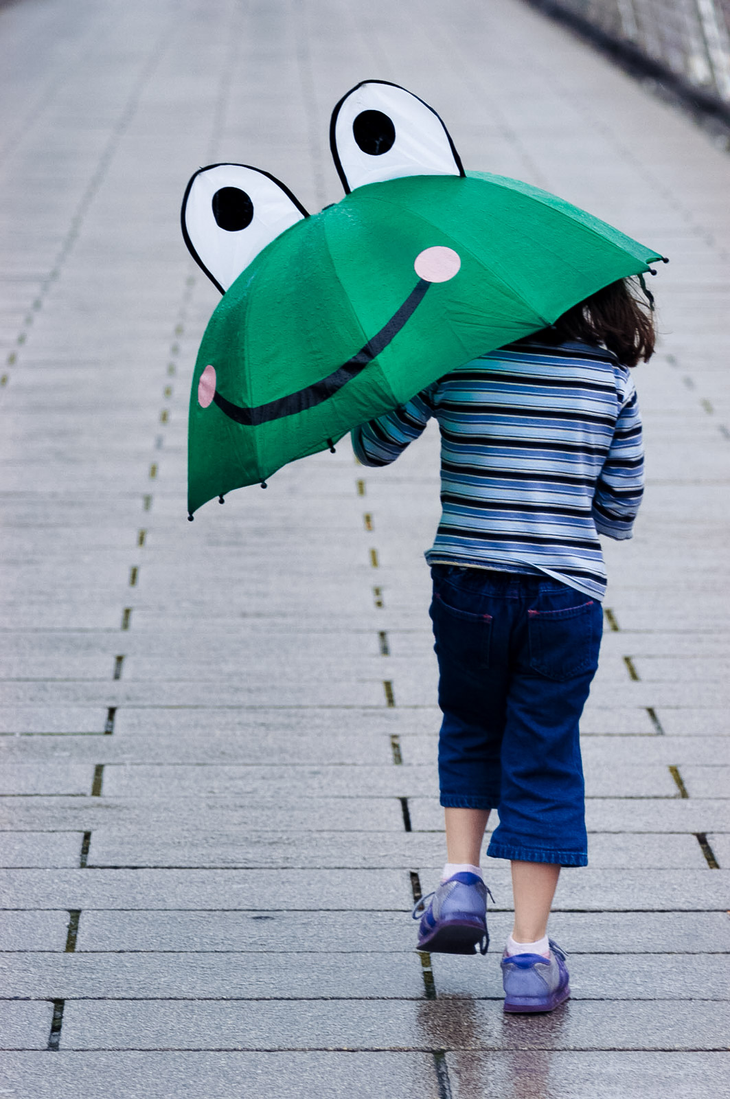 Another bank holiday weekend is forecast for rain. A little girls walks across the Golden Jubilee Bridge, London.